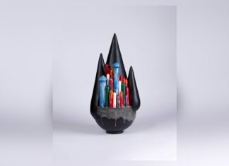 حين يصبح اللون الأبيض نادراً.. كيف يحاول الفنانون الإيرانيون إنقاذ فنهم من الحرب؟ عمل نحتي بأشكال عمودية ملونة بالأزرق والأحمر والأخضر داخل تكوين أسود ذي قمم مدببة، على خلفية فاتحة.