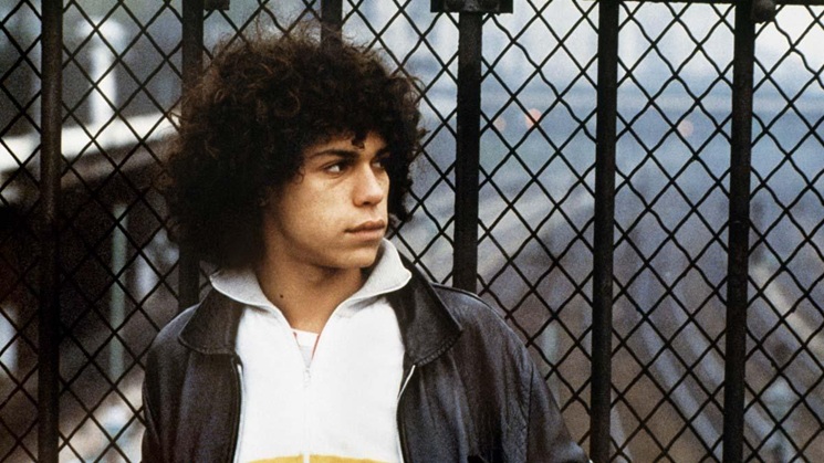 لقطة سينمائية لشاب أمام سياج معدني من فيلم الشاي في حريم أرخميدس للمخرج مهدي شارف عام 1985